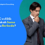 Pria muda mengenakan setelan jas abu-abu sedang memegang ponsel dan tampak berpikir serius dengan latar belakang hijau polos.