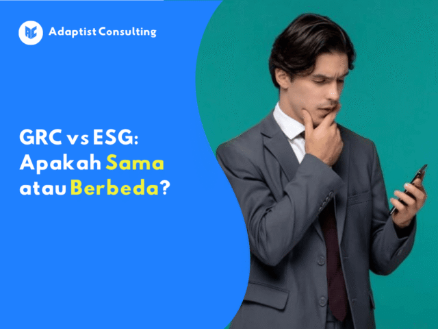 Pria muda mengenakan setelan jas abu-abu sedang memegang ponsel dan tampak berpikir serius dengan latar belakang hijau polos.