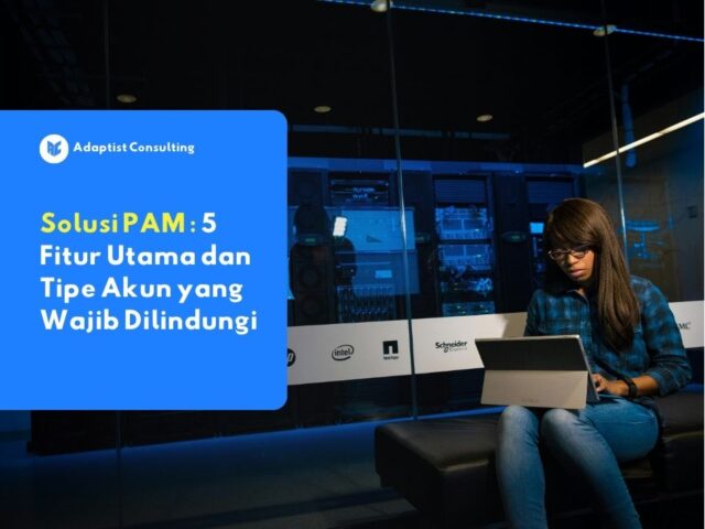 Karyawan yang sedang memantau dasbor keamanan siber dan mengelola hak akses sistem melalui platform Privileged Access Management (PAM) di ruang kontrol TI.