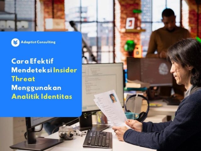 staf IT meninjau dokumen identitas karyawan di depan komputer.