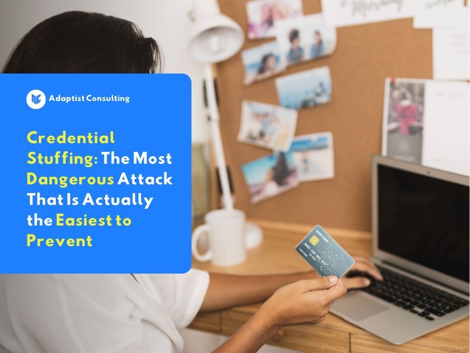A professional holding a credit card in front of a laptop, representing the threat of credential stuffing against business digital account security.