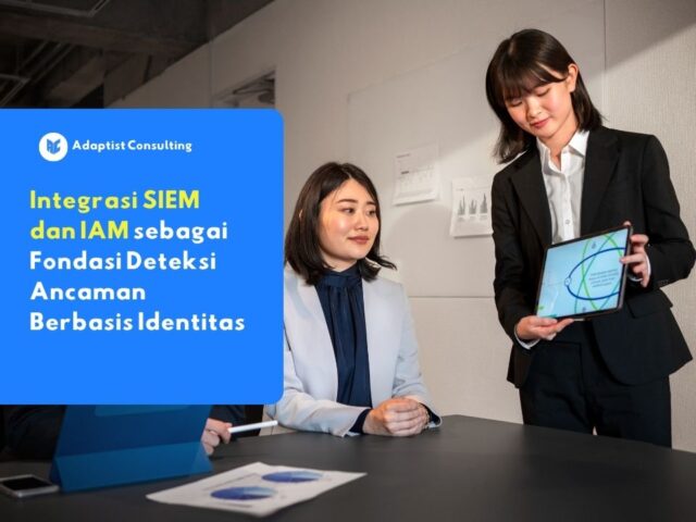 Profesional IT sedang berdiskusi menggunakan tablet mengenai Integrasi SIEM dan IAM sebagai fondasi deteksi ancaman berbasis identitas.