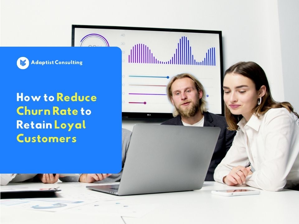 Employee is analyzing customer retention charts and churn rate metrics on a system dashboard on a computer monitor screen.