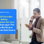 Karyawan customer service berbicara dengan pelanggan melalui telepon menggunakan nada bicara yang ramah dan profesional, menggambarkan penerapan voice dan tone yang konsisten dalam layanan pelanggan.