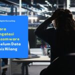 Tim IT menghadapi serangan ransomware saat mengakses server perusahaan, layar komputer menampilkan sistem terkunci dan gangguan keamanan siber di kantor modern.