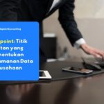 Seorang karyawan mengamati tiga perangkat sekaligus, yaitu laptop, smartphone, dan tablet, yang masing-masing terhubung ke jaringan perusahaan sebagai contoh nyata endpoint dalam lingkungan kerja sehari-hari.