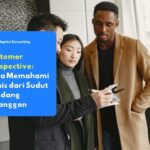 Tiga profesional bisnis sedang meninjau laporan dan dokumen di atas meja, mendiskusikan data analisis customer perspective bersama-sama.