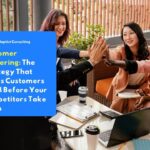 A group of professionals joining hands together in a team huddle during a customer gathering event.