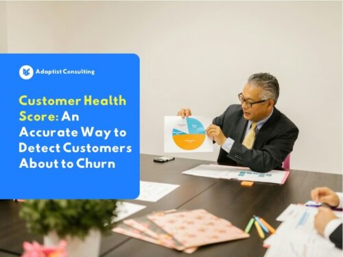 An employee is analyzing a client retention graph on a monitor screen to evaluate the company's Customer Health Score matrix.