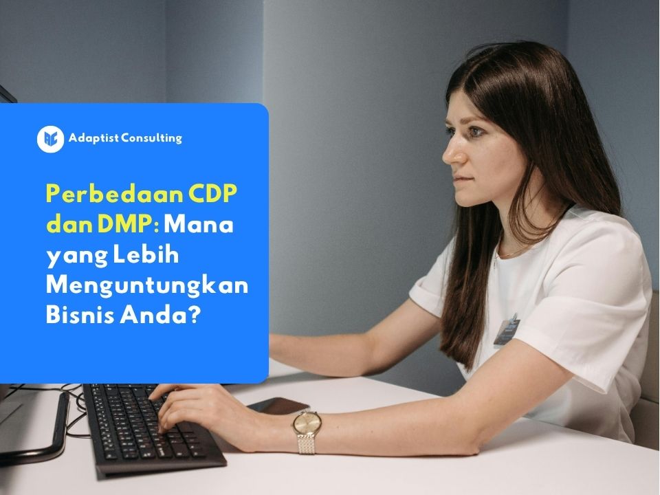 Karyawan yang sedang membandingkan arsitektur sistem CDP dan DMP melalui layar dashboard untuk strategi manajemen data perusahaan.